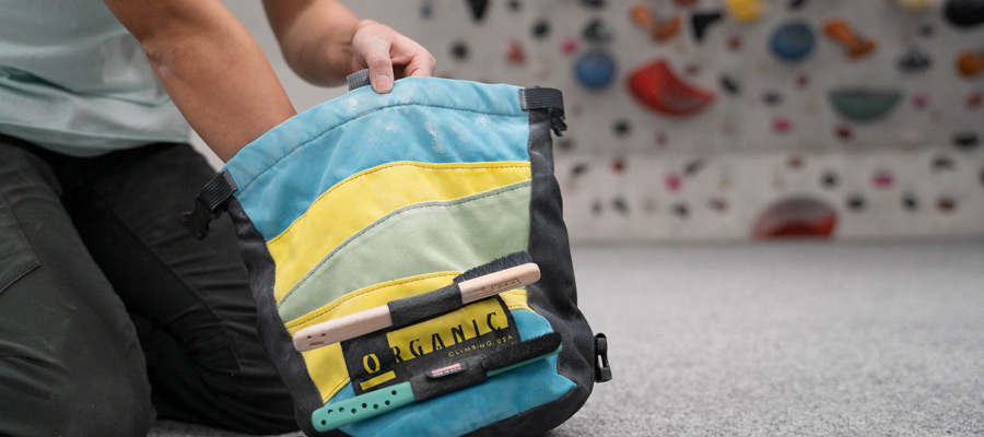 person chalking up inside bouldering bucket